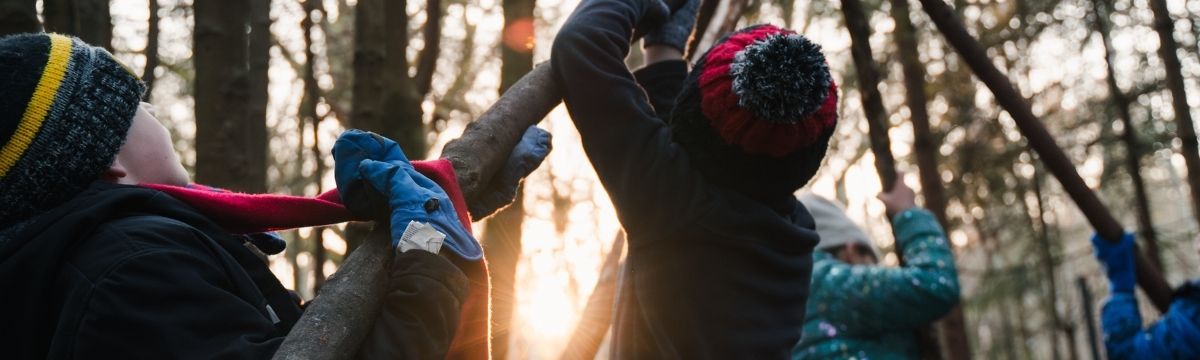Children building a shelter with fallen branches
