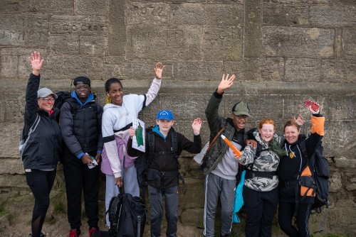 Group smiling and waving on their expedition