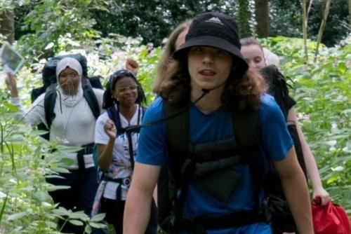 Young people trekking through a forest