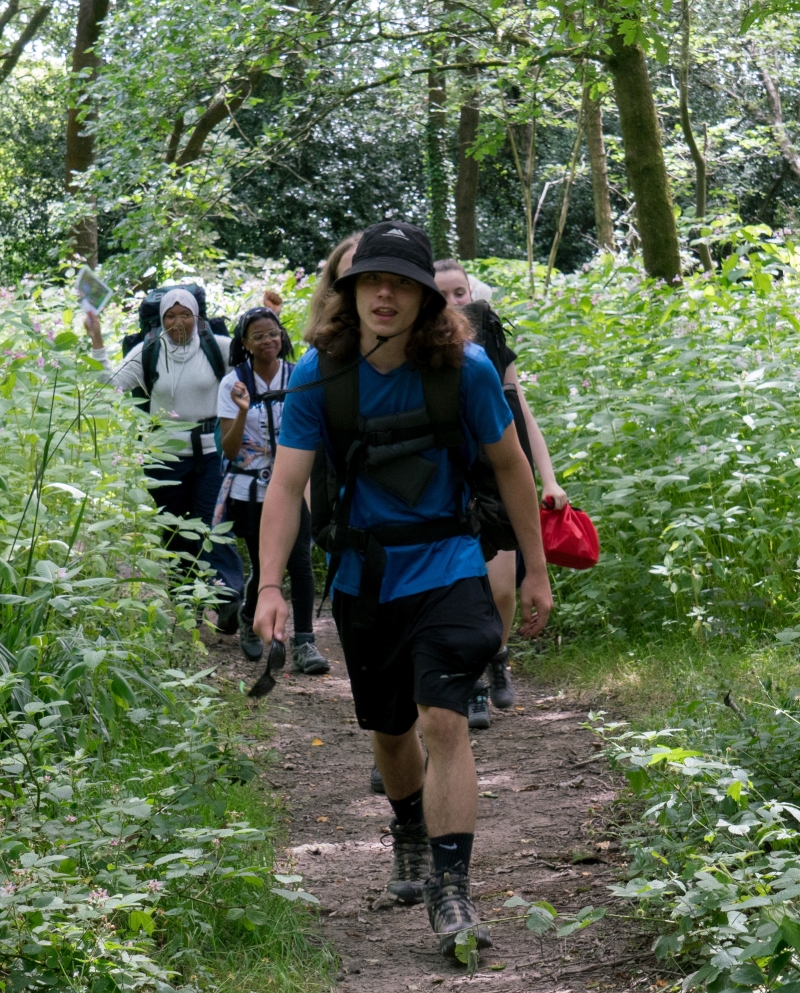 A group of young people trekking through a forest