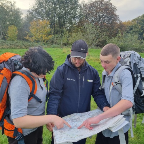 Three people gathered round looking at a map