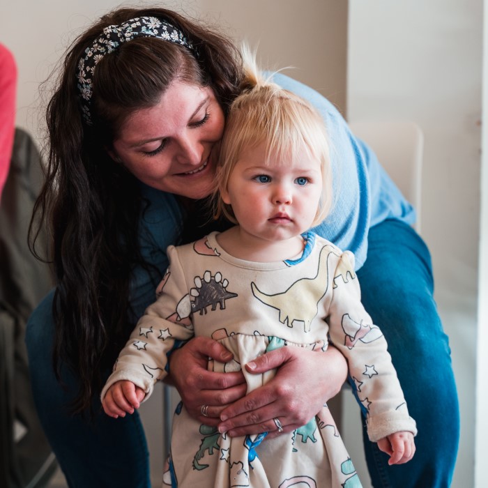 Little girl standing getting a hug from Mum