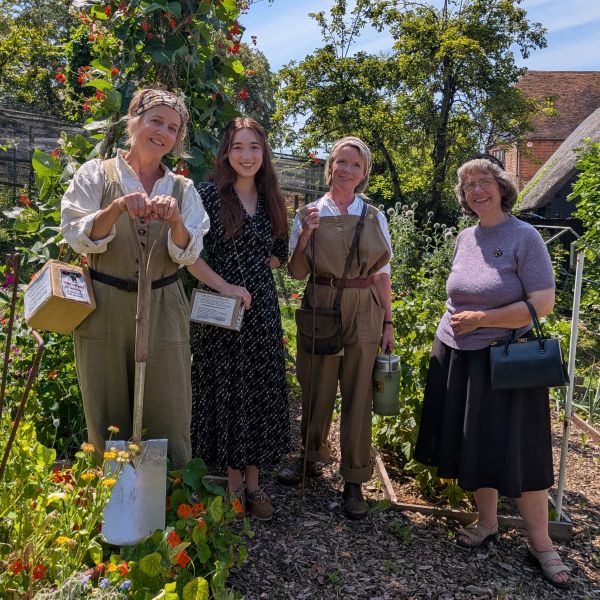 Group of adults wearing wartime farming clothing