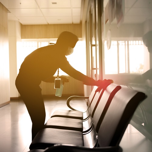 A person cleaning a row of chairs