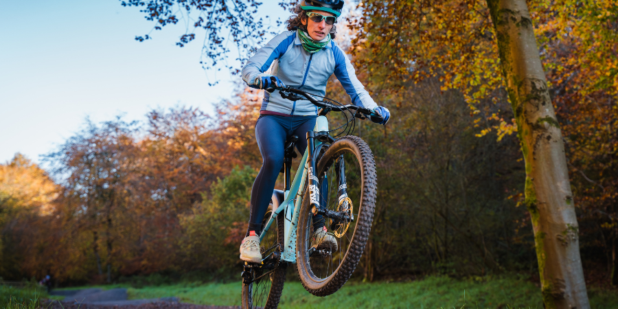Person cycling along a trail in the woods
