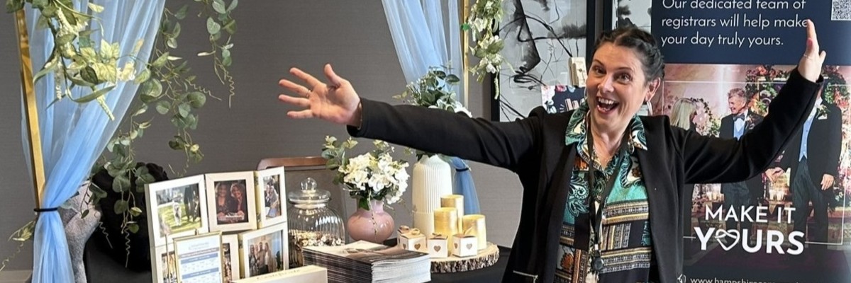 A happy woman standing in front of a wedding display table