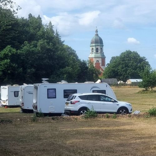 Caravans and motorhomes parked at Royal Victoria Country Park with the Chapel in the background