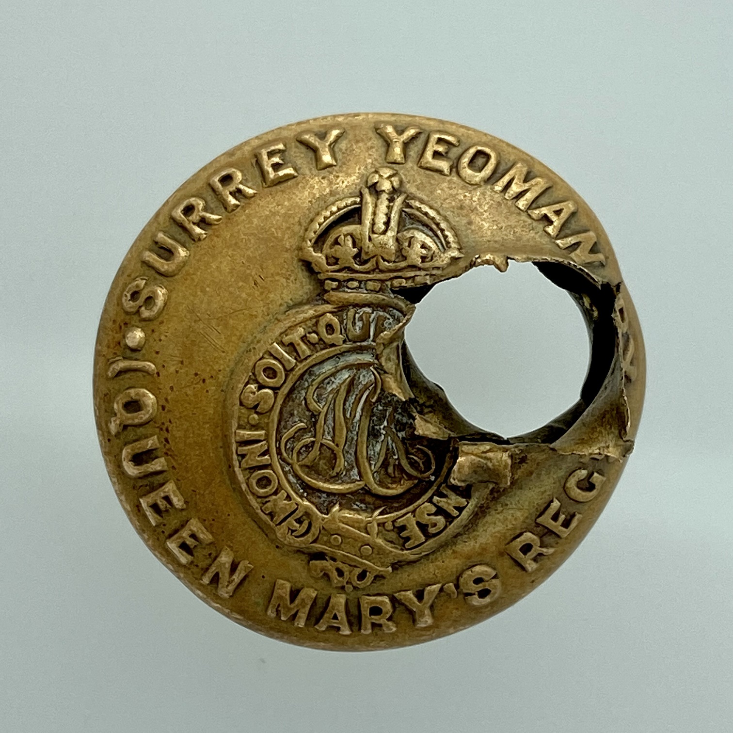 Military tunic button with hole in it made from a bullet.