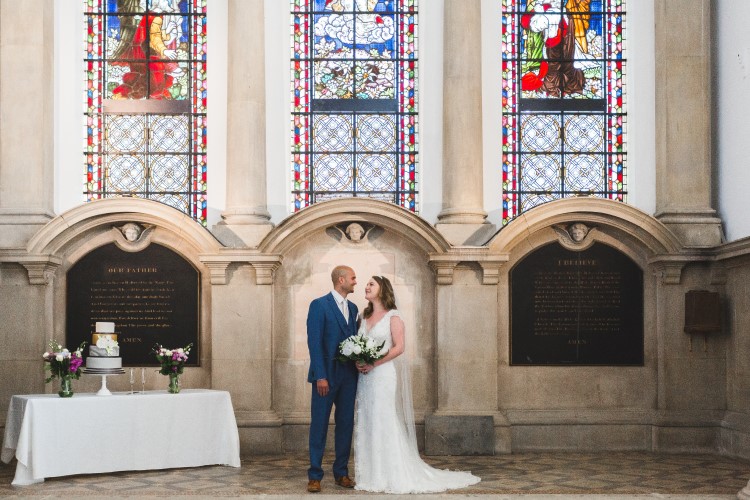 Bride and groom in front of a stained glass window