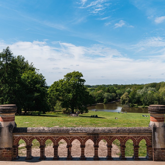 View from a balcony across grassland and a lake 