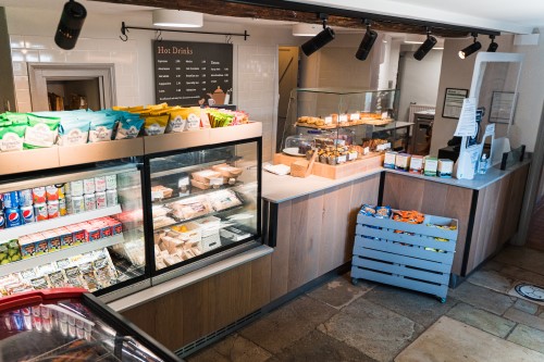 Inside the tea rooms with a counter full of drinks, snacks and baked goods