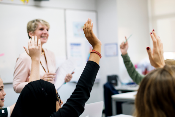 classroom with hands up
