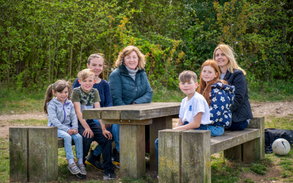 A group of adults and children sat at a picnic table