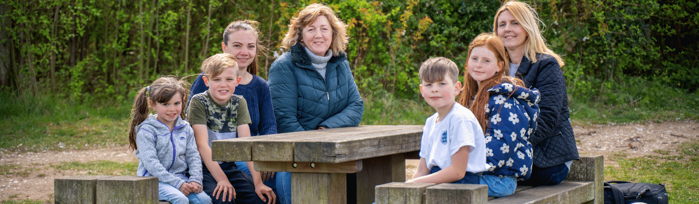 A group of adults and children sat at a picnic table
