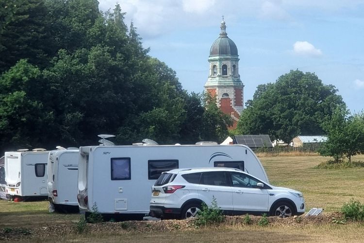 Caravans and motorhomes parked at Royal Victoria Country Park with the Chapel in the background